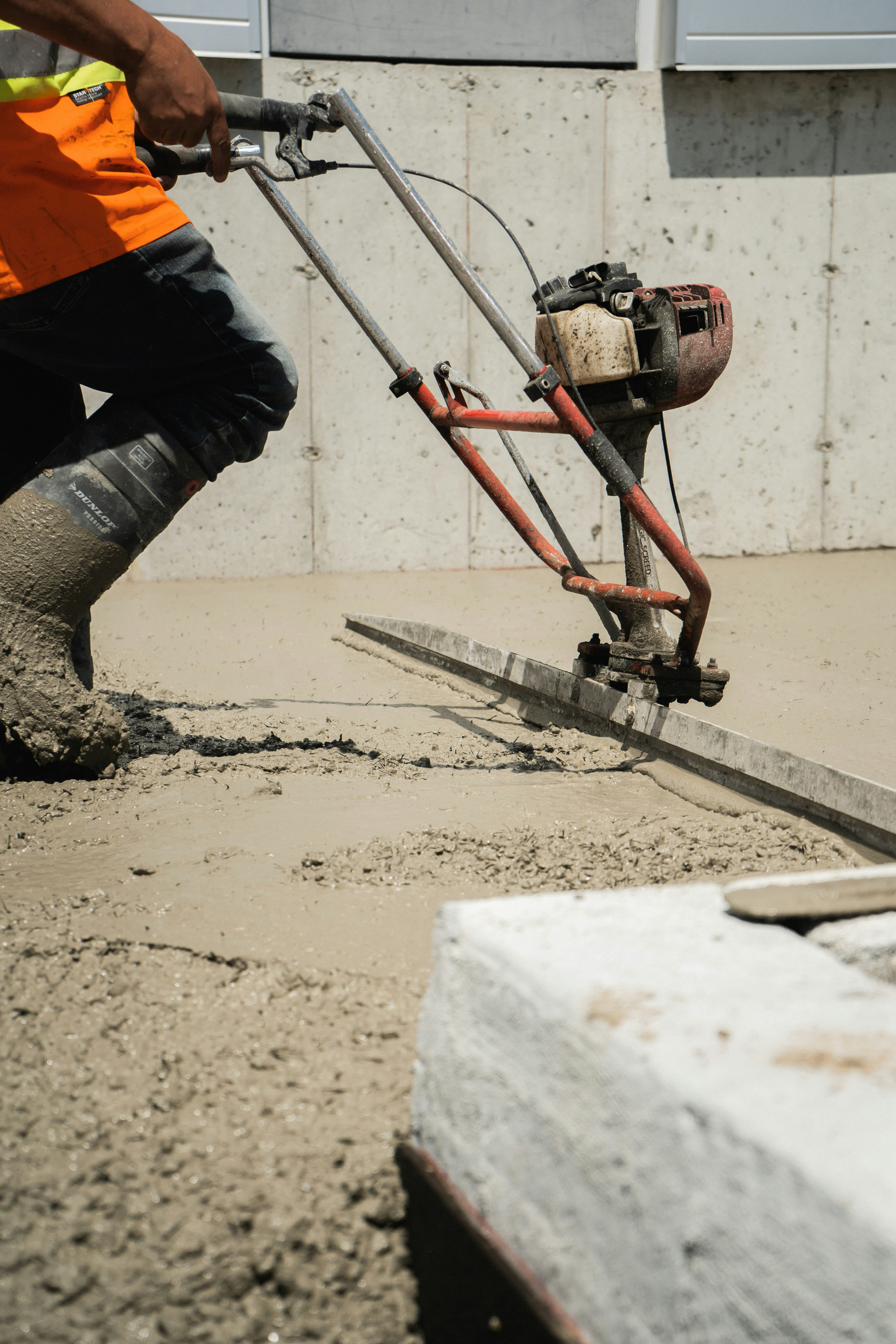 Finition d'une dalle béton à la taloche mécanique sur un chantier